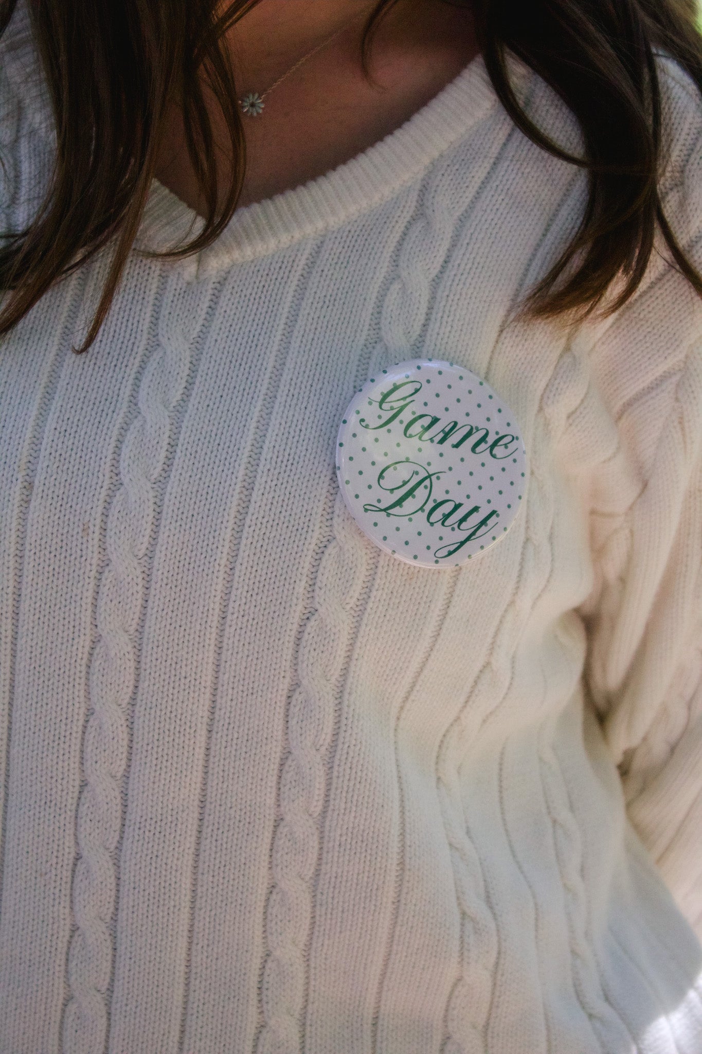 White sweater with a 'Game Day' button 