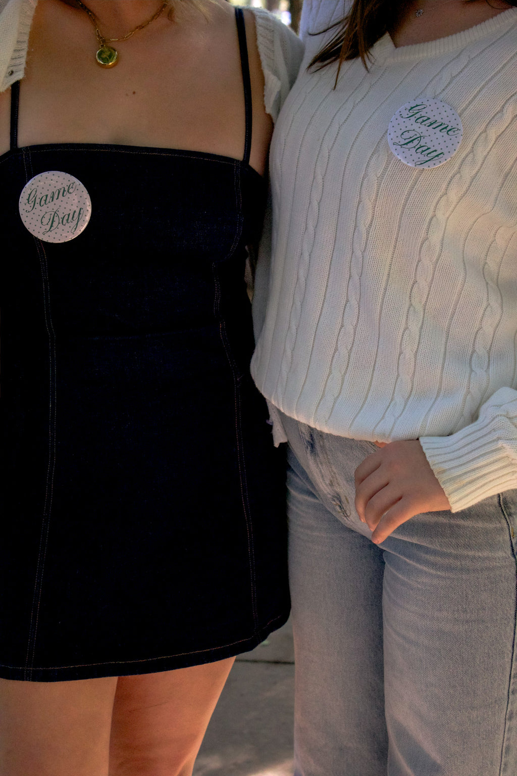 Two people wearing 'Game Day' pins