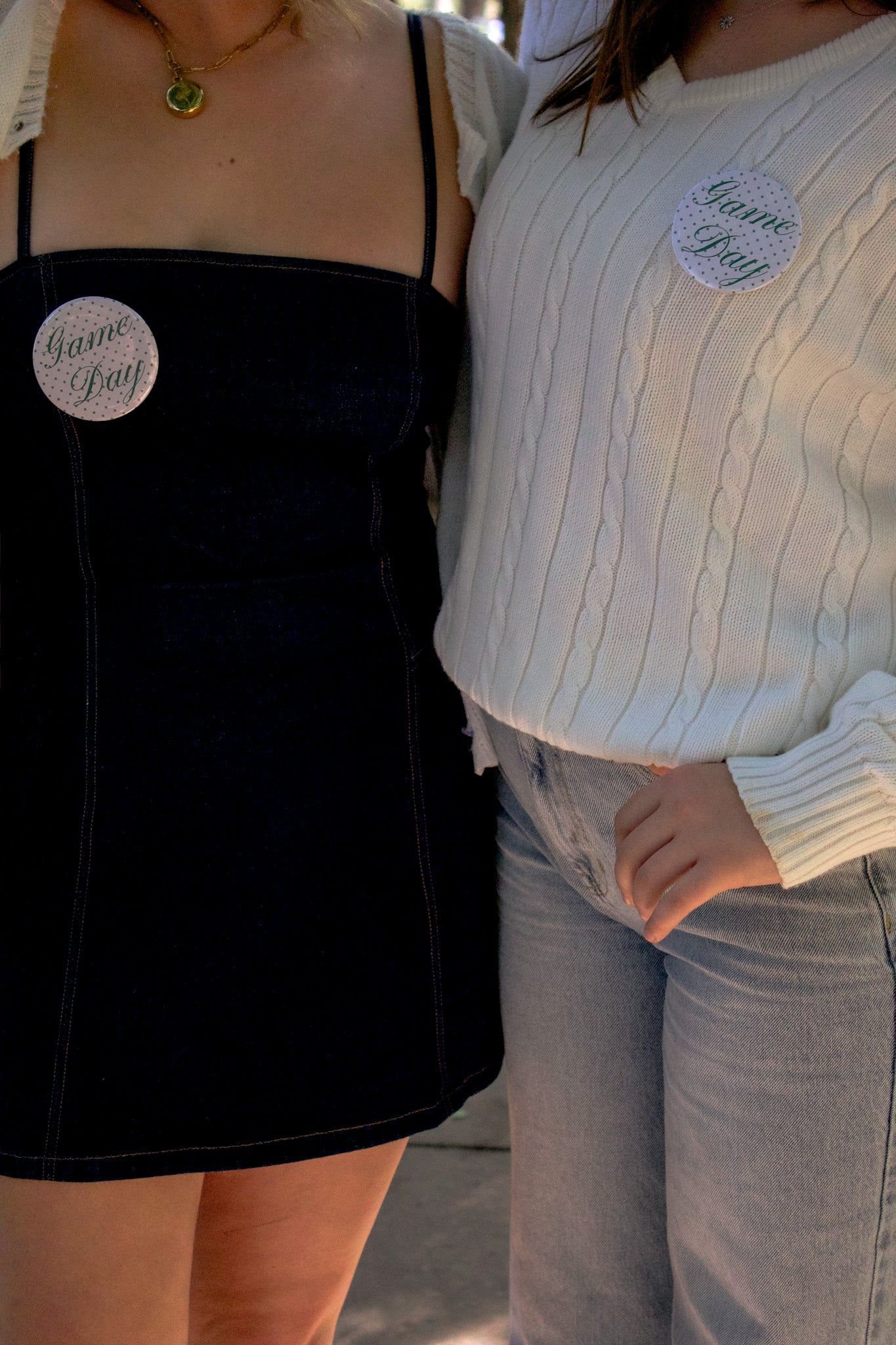 Two people wearing 'Game Day' pins